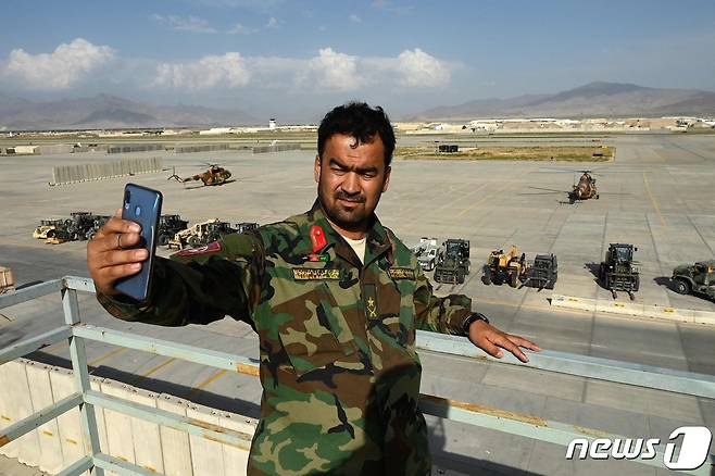아프가니스탄 수도 카불 북부 인근 미국 군사기지에 주둔하던 미군과 북대서양조약기구(나토)군 철수하자 한 정부군이 자신의 핸드폰으로 기념사진 촬영을 하고 있다. (본문과 관련없음) 2021.07.05 © AFP=뉴스1