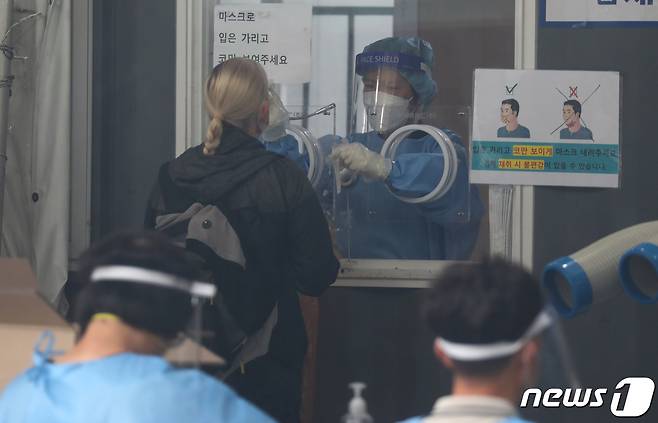29일 오전 서울 중구 서울역 광장에 마련된 신종 코로나바이러스 감염증(코로나19) 임시선별검사소에서 한 외국인이 검체 검사를 받고 있다. 질병관리청 중앙방역대책본부는 29일 0시 기준 코로나19 신규 확진자가 2885명 발생했다고 밝혔다. 지난 25일 0시 기준 신규 확진자 3273명에 이어 역대 두 번째로 많이 나온 규모다. 2021.9.29/뉴스1 © News1 김명섭 기자