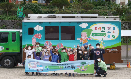 코오롱그룹의 비영리재단인 꽃과어린왕자가 운영하는 '찾아가는 에너지학교, 에코 롱롱'이 28일 울릉도 천부초등학교를 찾아 친환경 에너지 교육 프로그램을 진행했다. 사진은 학생들이 교육 차량 앞에서 단체사진을 찍고 있는 모습. <코오롱 제공>