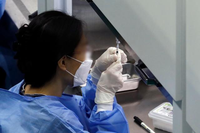 28일 서울 동대문구 예방접종센터에서 의료진이 백신을 주사기에 담고 있다. 1차 접종 완료자 수는 누적 3,851만1,292명(인구 대비 75.0%)이다. 뉴시스