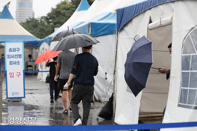 서울시 송파구 올림픽공원 코로나19 임시 선별진료소에서 29일 시민들이 우산을 쓴 채 검사를 받기 위해 줄 서있다. 29일 0시 기준 신규 확진자는 2885명으로 누적 확진자는 30만8725명이다. /한수빈 기자