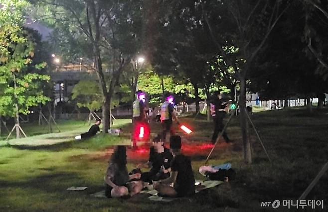 26일 저녁 술자리가 벌어지고 있는 서울 광진구 뚝섬한강공원을 경찰관들이 순찰하고 있다. / 사진 = 오진영 기자