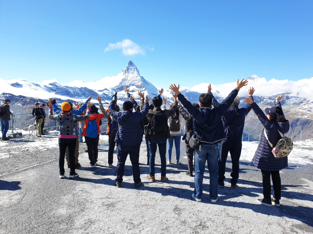지난 21일(현지시간) 스위스 고르너그라트 전망대를 찾은 한국인 관광객들이 알프스산맥 마테호른을 바라보며 두 팔을 활짝 들어 보이고 있다./사진제공=롯데관광