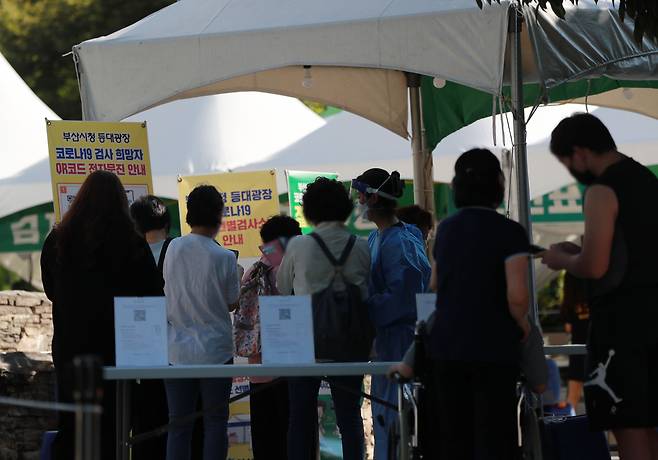 23일 오후 부산 연제구 부산시청 등대광장에 마련된 임시선별진료소에서 시민들이 코로나 검사를 받고 있다./연합