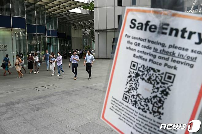 싱가포르 금융 지구 래플스 플레이스의 2021년 9월 14일 모습. 코로나19 방역 관련 접촉자 추적을 위한 큐알(QR) 코드 태깅을 안내하는 포스터가 붙어 있다.  © AFP=뉴스1