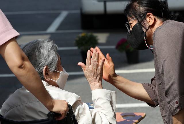 추석을 하루 앞둔 지난달 20일 오전 강원 춘천시의 한 요양원에서 입소 어르신이 딸과 면회하며 작별 인사를 하고 있다. /연합뉴스