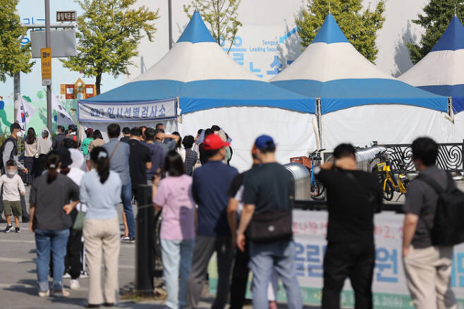 1일 서울 송파구 올림픽공원 앞에 설치된 임시선별검사소에서 시민들이 코로나19 검사를 받기 위해 줄을 서있다. 연합뉴스
