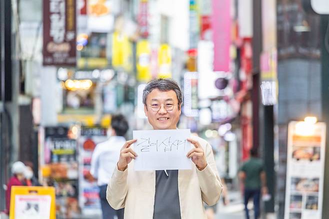 자영업자 온라인 손팻말 시위 돌풍을 일으킨 김유진씨가 서울 명동 거리에서 ‘같이 삽시다’라고 직접 매직펜으로 쓴 종이를 들었다. 김씨는 “모두 같이 잘 살자는 뜻에서 썼다”고 했다. /김종연 영상미디어 기자