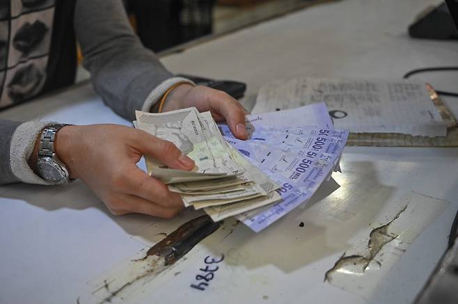 베네수엘라의 수도 카라카스 인근 카티아의 시장에서 지난 8월 5일(현지시각) 한 남성이 지폐를 세고 있다. /연합뉴스