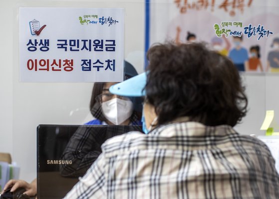지난달 10일 서울 성북구 길음1동 주민센터에 한 주민이 국민지원금 관련 이의신청을 하고 있다. 연합뉴스