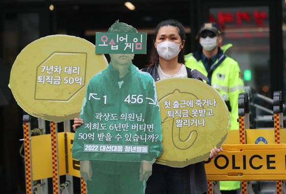 대장동 개발 사업을 둘러싼 정치권의 공방이 계속된 29일 서울 영등포구 국민의힘 중앙당사 앞에서 2022 대선대응 청년행동 관계자가 곽상도 의원 아들의 50억 퇴직금을 비판하는 피켓을 들고 있다. 뉴스1
