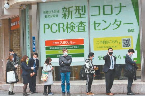 일본 도쿄 신바시에 있는 민간 코로나19 PCR 검사 센터 앞에 마스크를 쓴 시민들이 줄을 서 있다. [AP=연합뉴스]