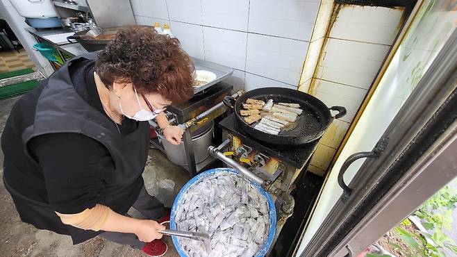 (Yangji sikdang owner) Pyun Soon-ja, owner-chef of Yangji sikdang, prepares galchigui, pan-fried cutlassfish. (Kim Hae-yeon/ The Korea Herald)