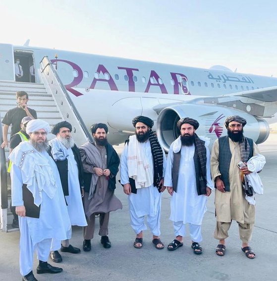 탈레반 고위급 대표단이 미국과의 회담을 앞둔 지난 8일 카타르 항공기 앞에서 기념촬영을 하고 있다. [연합뉴스]