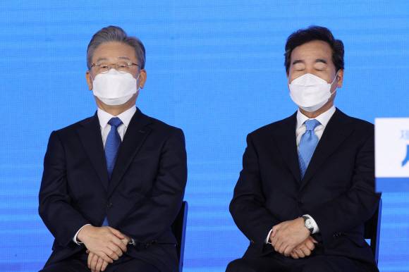 더불어민주당 대선 후보로 선출된 이재명(왼쪽) 경기지사와 간발의 차이로 이 후보의 본선 직행을 막지 못한 이낙연 전 대표가 10일 서울 송파구 올림픽공원 핸드볼경기장에서 열린 서울 지역 권리당원·대의원 투표 및 3차 국민·일반당원 선거인단 투표 개표식에서 나란히 앉아 있다.김명국 선임기자 dausno@seoul.co.kr