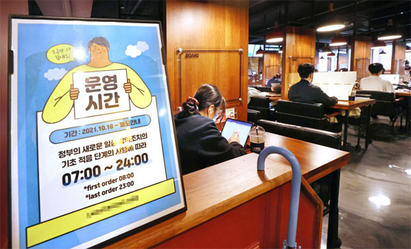 정부의 새 거리 두기 조정안이 발표된 15일 서울의 한 스터디카페 출입구에 영업시간 안내문이 놓여 있다. [사진 출처 = 연합뉴스]