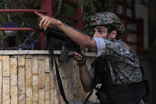14일(현지시간) 레바논 베이루트에서 벌어진 총격전의 확산을 막기 위해 투입된 한 군인이 저격수를 손가락으로 가리키고 있다. 베이루트=AP연합뉴스