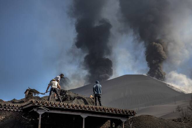 지난 14일 주민들이 지붕 위를 뒤덮은 화산재를 치우고 있다. 사진=AP 연합뉴스