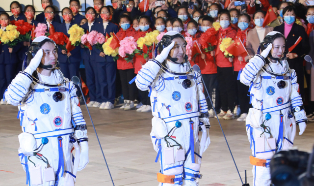 중국의 독자 우주정거장 건설을 위한 두번째 유인우주선에 탑승한 세명의 우주비행사 (왼쪽부터)예광푸, 자이즈강, 왕야핑이 15일 출발을 앞두고 환영행사에서 인사하고 있다. /신화연합뉴스