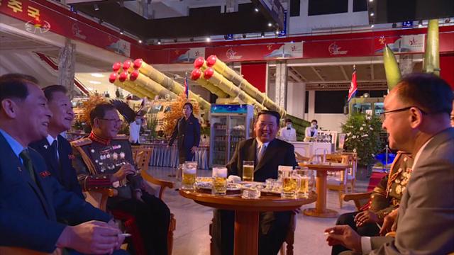 김정은 국무위원장이 11일 평양 3대혁명전시관에서 열린 국방발전전람회 개막식에 참석해 당 간부들과 맥주를 마시고 있다. 조선중앙TV 뉴시스