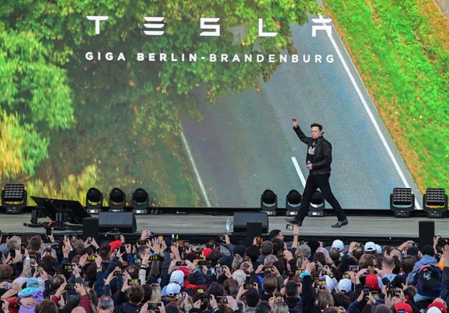 미국 전기차회사 테슬라의 일론 머스크가 9일 독일 베를린 외곽 그륀하이데 테슬라 생산기지에서 열린 축제 무대에 도착해 인파의 환영을 받고 있다. 그륀하이데=AP 연합뉴스