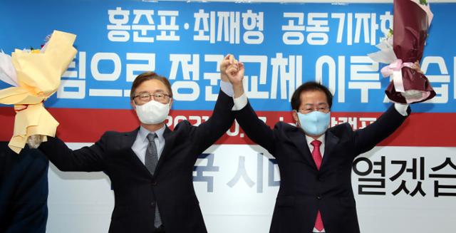국민의힘 대선주자인 홍준표(오른쪽) 의원이 17일 서울 여의도 대선캠프 사무실에서 기자회견을 열고 최재형 전 감사원장의 캠프 합류를 알리며 손을 맞잡아 들어보이고 있다. 뉴시스
