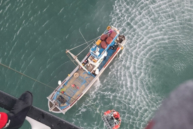 18일 인천시 옹진군 선미도 인근 해상에서 사고로 전복된 7.93t급 어선 A호의 선원들을 해경이 구조하고 있다. (사진=연합뉴스)
