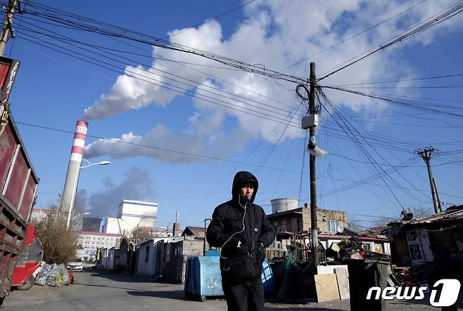 한 시민이 중국 헤이룽장성 하얼빈에 위치한 석탄 화력 발전소 인근을 걸어가고 있다. © 로이터=뉴스1