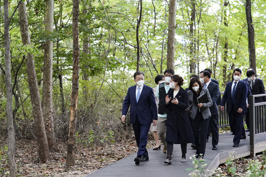 18일 문재인 대통령이 서울 용산에서 진행한 2050 탄소중립위원회 제2차 전체회의 후 숲을 이동하고 있다. 청와대 제공.