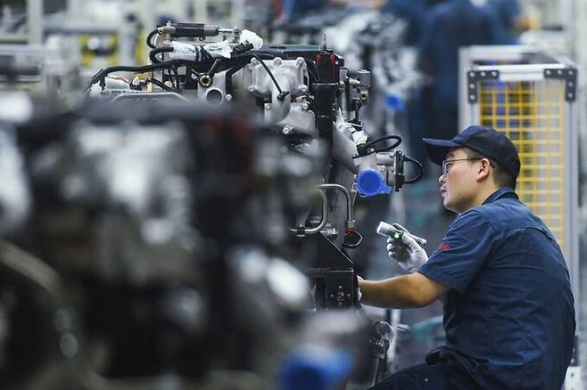 중국 동부 저장성 항저우에 자리한 트럭공장에서 노동자가 중형 트럭 엔진을 살피고 있다. 항저우/AFP 연합뉴스