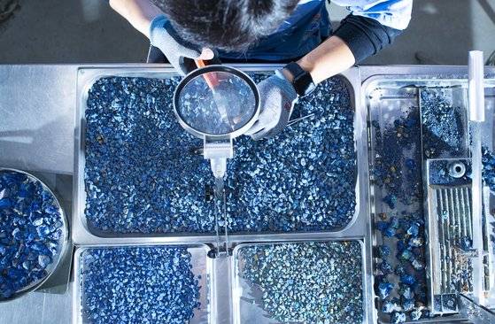 전통 안료인 석채를 만드는 과정. 청금석을 잘게 쪼갠 뒤 돋보기를 놓고 불순물을 펜치로 끊어내고 있다. 권혁재 기자