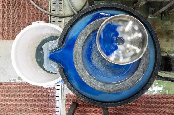 원석을 잘게 쪼갠 뒤 특수 제작 맷돌에 물을 부어 식혀가며 갈아낸다. 초반에는 불순물이 섞여 또렷한 색이 나오지 않는다. 사진은 푸른색을 내는 남동광을 갈아내는 과정에서 불순물 섞인 땟물이 섞인 부분이 연한 하늘색으로 나타나는 모습. 권혁재 기자