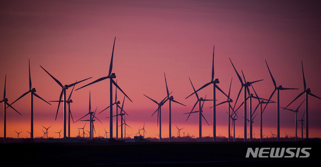 [보르델룸=AP/뉴시스]9일(현지시간) 독일 보르델룸 북해 인근의 한 풍력 발전소에 풍력 터빈이 지는 해를 배경으로 붉게 물들어 있다. 2021.03.10.