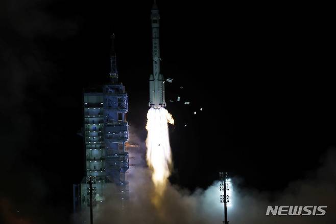 [AP/뉴시스] 16일 중국의 유인우주선 선저우13호가 고비 사막의 주취안 위성발사센터에서 장정2F 로켓에 실려 발사되고 있다