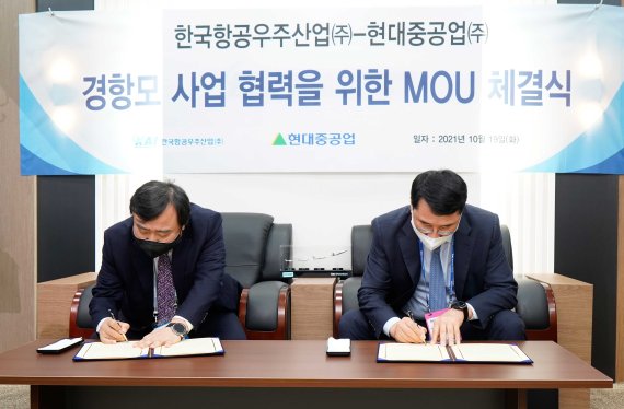 안현호 한국항공우주산업(KAI) 사장(왼쪽)과 한영석 현대중공업 부회장이 19일 성남시 서울공항에서 '한국형 경항공모함 기본설계 사업협력을 위한 양해각서(MOU)'를 체결하고 있다.