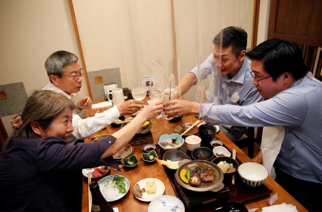 신종 코로나바이러스 감염증(코로나19) 확산 방지를 위한 긴급사태 선언이 일본 전역에서 해제된 지난 1일, 음식점에서 주류 판매가 다시 허용돼 손님들이 건배를 외치며 술잔을 부딪치고 있다. 도쿄=로이터 연합뉴스