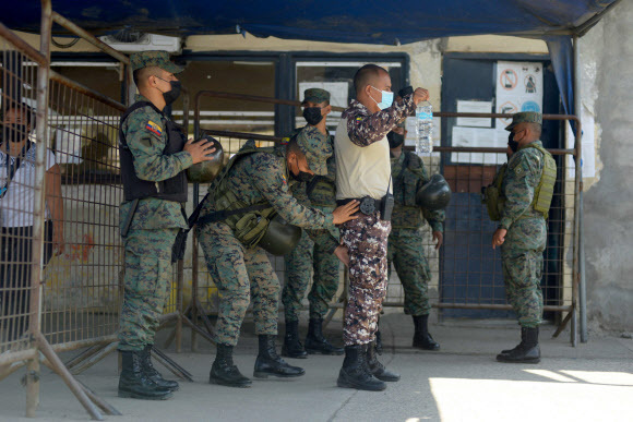 지난달 28일(현지시간) 에콰도르 콰야킬의 리토랄 교도소에서 갱단 소속 재소자 간에 서로 수류탄 등을 이용해 공격하는 등 폭동이 발생한 가운데 군이 출동해 이를 진압하고 있다. 콰야킬=AFP연합
