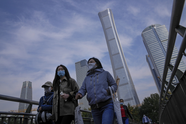 지난 18일 중국 베이징의 중심가에서 시민들이 마스크를 쓴 채 길을 서두르고 있다. /AP연합뉴스