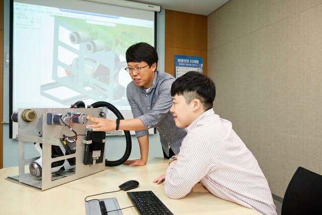 정우현 삼성디스플레이 프로(왼쪽)와 박광돈 프로가 크레인 클리닝 로봇을 보고 있다.(사진=삼성디스플레이)