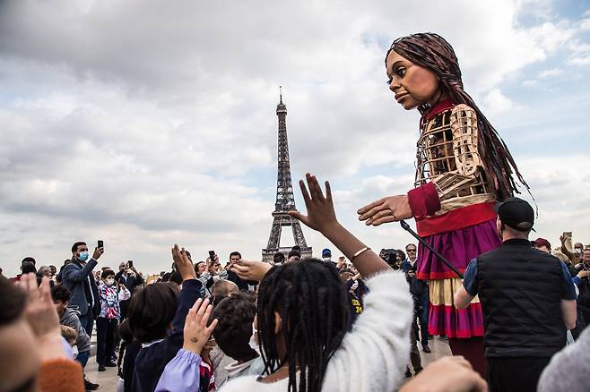 15일(현지 시각) 프랑스 파리 에펠탑 앞에 도착한 리틀 아말을 향해 사람들이 손을 흔들고 있다/EPA 연합뉴스