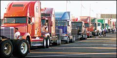 9일 미국 롱비치 항구 출입구 앞에서 트럭 운전사들이 항만 하역작업 재개를 기다리고 있다.