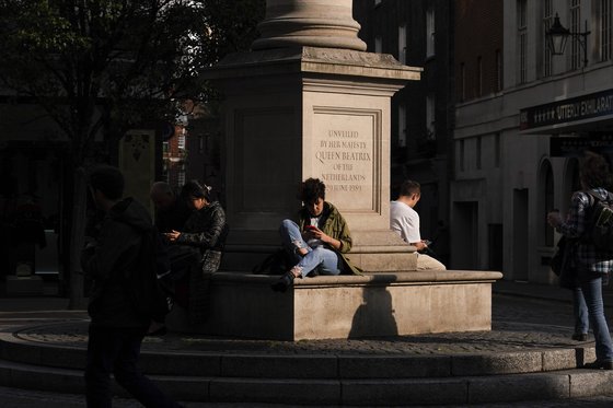 19일(현지시간) 마스크를 쓰지 않은 시민들이 영국 런던의 코벤트 가든 거리에 앉아 있다. [AP=연합뉴스]