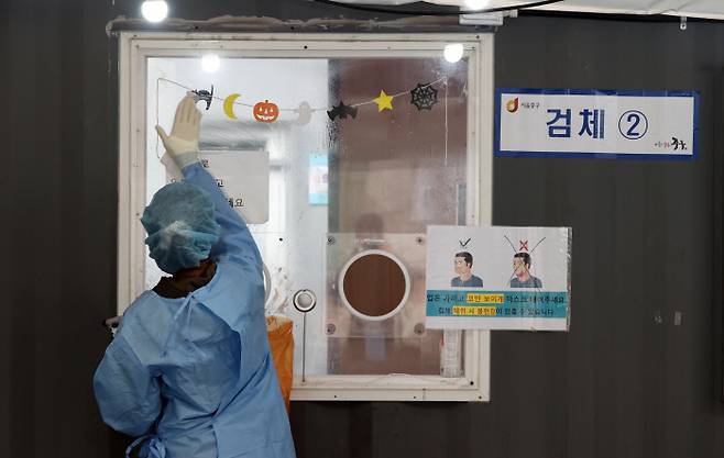 19일 서울역광장에 마련된 신종 코로나19 임시선별검사소에서 의료진이 소독작업을 하고 있다. 연합뉴스