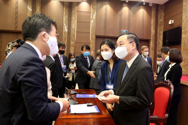 Hà Nội"s leaders talk to foreign investors at an event held in-person in the capital city on Tuesday. — VGP Photo