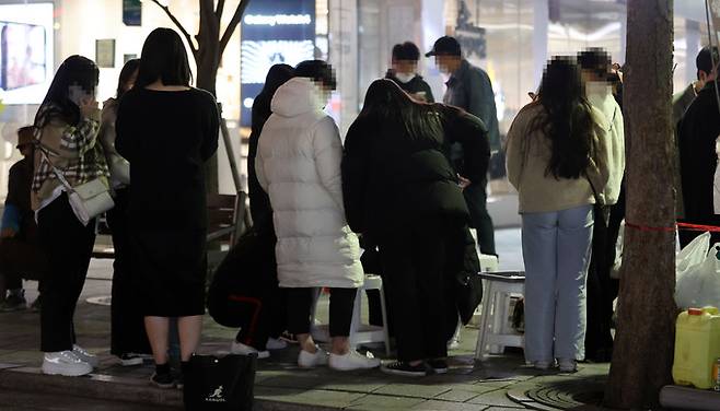이례적인 가을 한파가 닥친 17일 서울 마포구 홍대거리에서 두툼한 옷을 입은 시민들이 달고나 게임을 하고 있다. 연합뉴스