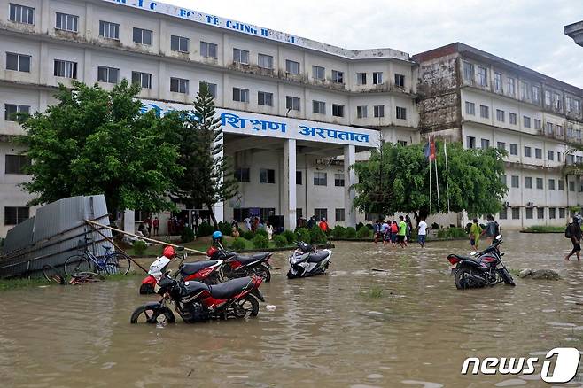 20일(현지시간) 네팔과 인도에 며칠간 이어진 홍수와 산사태로 사망자가 100명이 넘었다. 사진은 네팔 비라트나가르에서 사람들이 폭우로 침수된 도로를 걸어가는 모습. © AFP=뉴스1 © News1 신윤하 기자