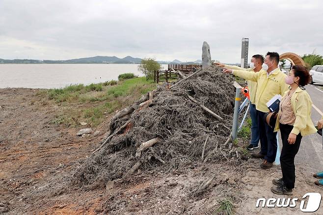 지난 7월 집중호우로 영산강변에 수해쓰레기가 쌓이면서 민원이 발생하자, 김산 무안군수(오른쪽에서 두번째)와 직원들이 복구 현장을 찾아 작업상황을 지켜보고 있다.2021.9.10/뉴스1
