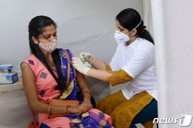 지난 8월 25일 인도 뭄바이에서 한 여성이 코비실드 백신을 맞는 모습.  © AFP=뉴스1