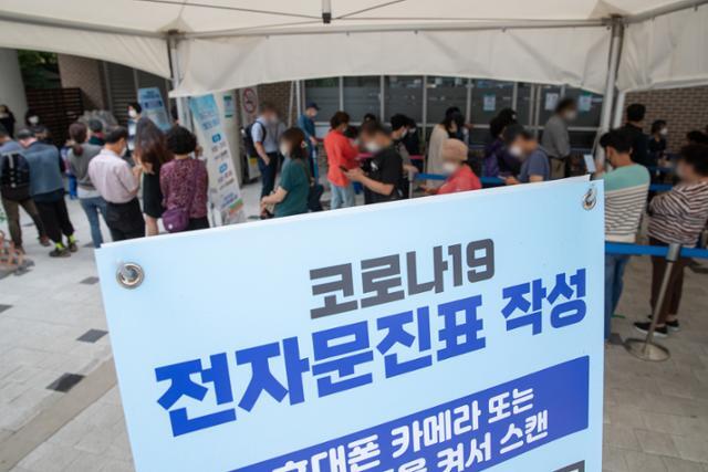 10월 4일 오후 서울 마포구보건소에 마련된 신종 코로나바이러스 감염증(코로나19) 선별진료소를 찾은 시민들이 검체검사를 받기 위해 줄을 서 있다. 뉴스1