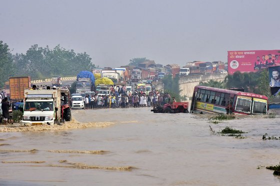 인도와 네팔에서 발생한 홍수와 산사태로 도로가 침수돼 통근자들이 고가 위에 서 있다. 연합뉴스